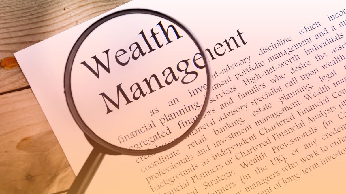 Magnifying glass over the words Wealth Management on a printed page